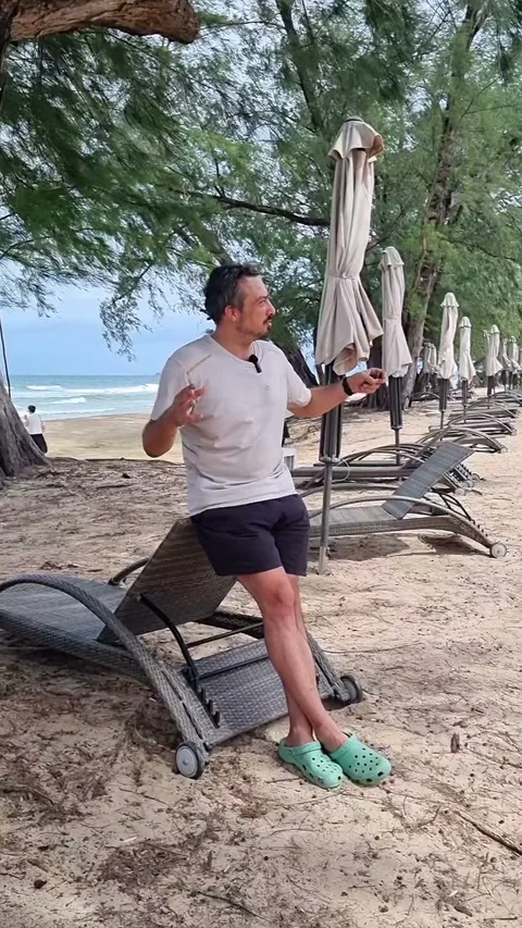 Тропический пляж Фукуока с пальмами, лежаками и закрытыми пляжными зонтиками