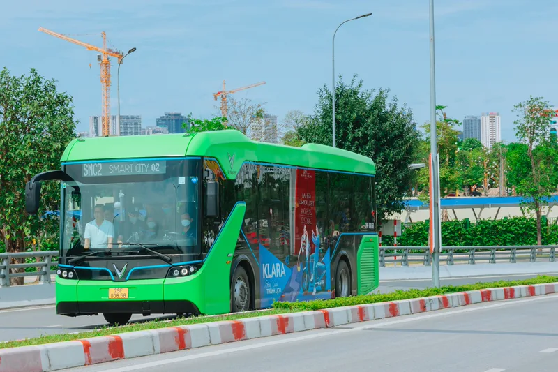 Зелёный электробус VinBus на улице Фукуока